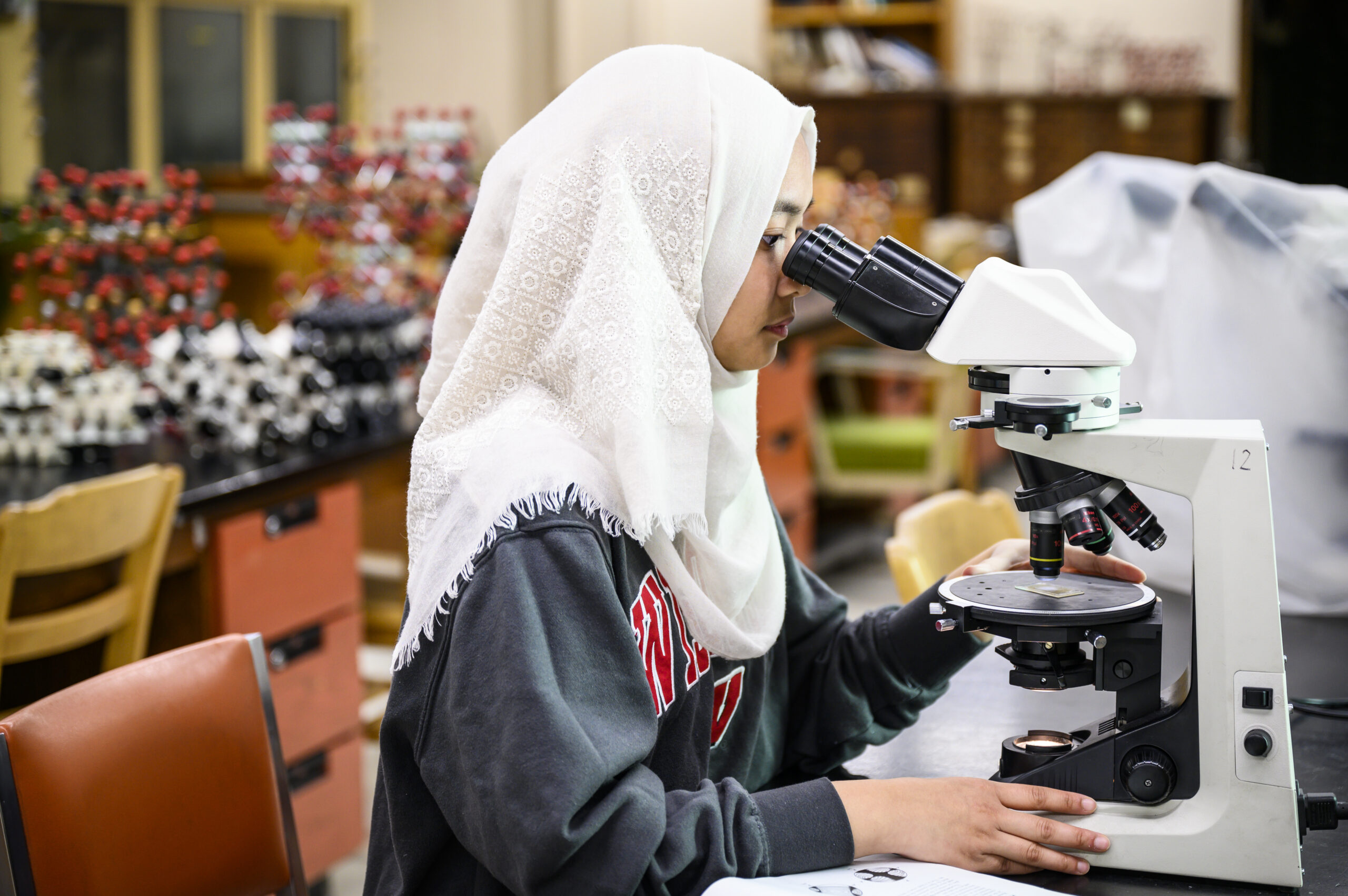 A student uses a microscope in a lab.